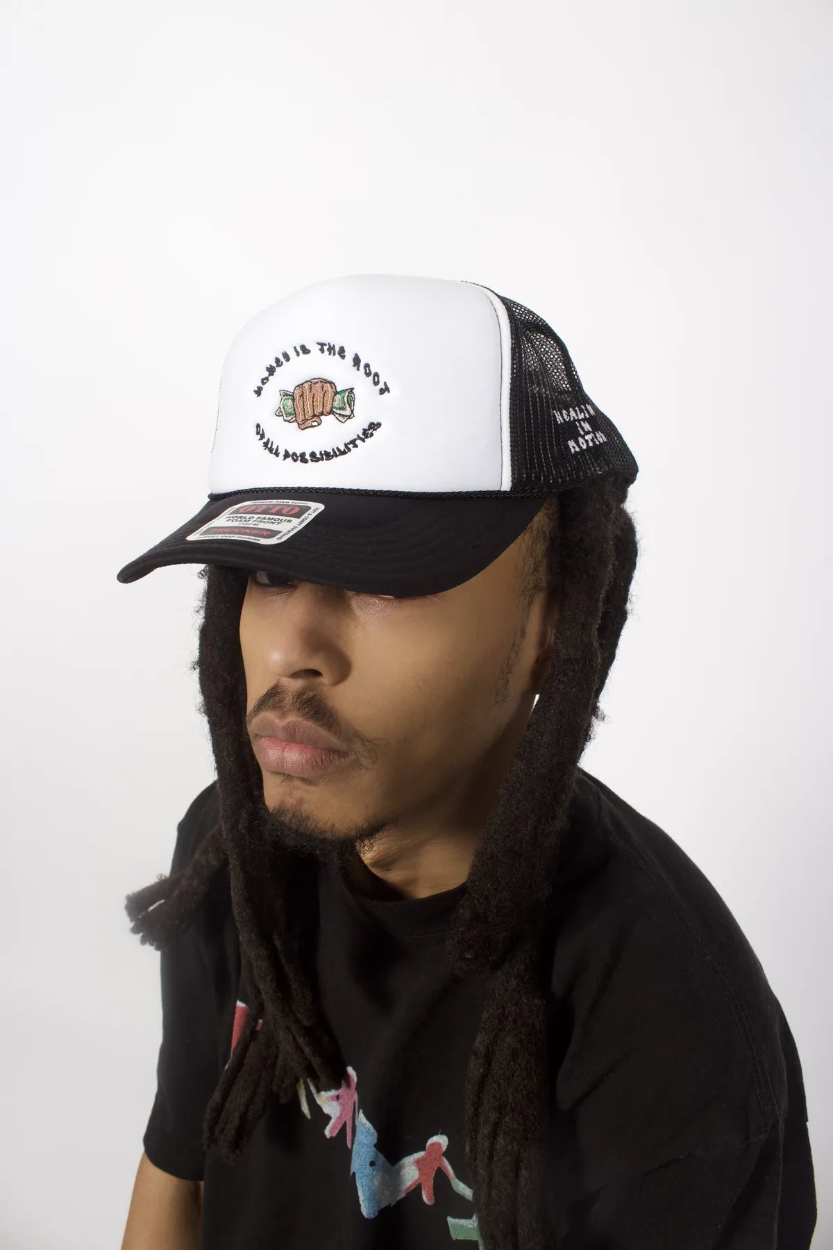 Model wearing the black and white Money Is the Root of All Possibilities hat